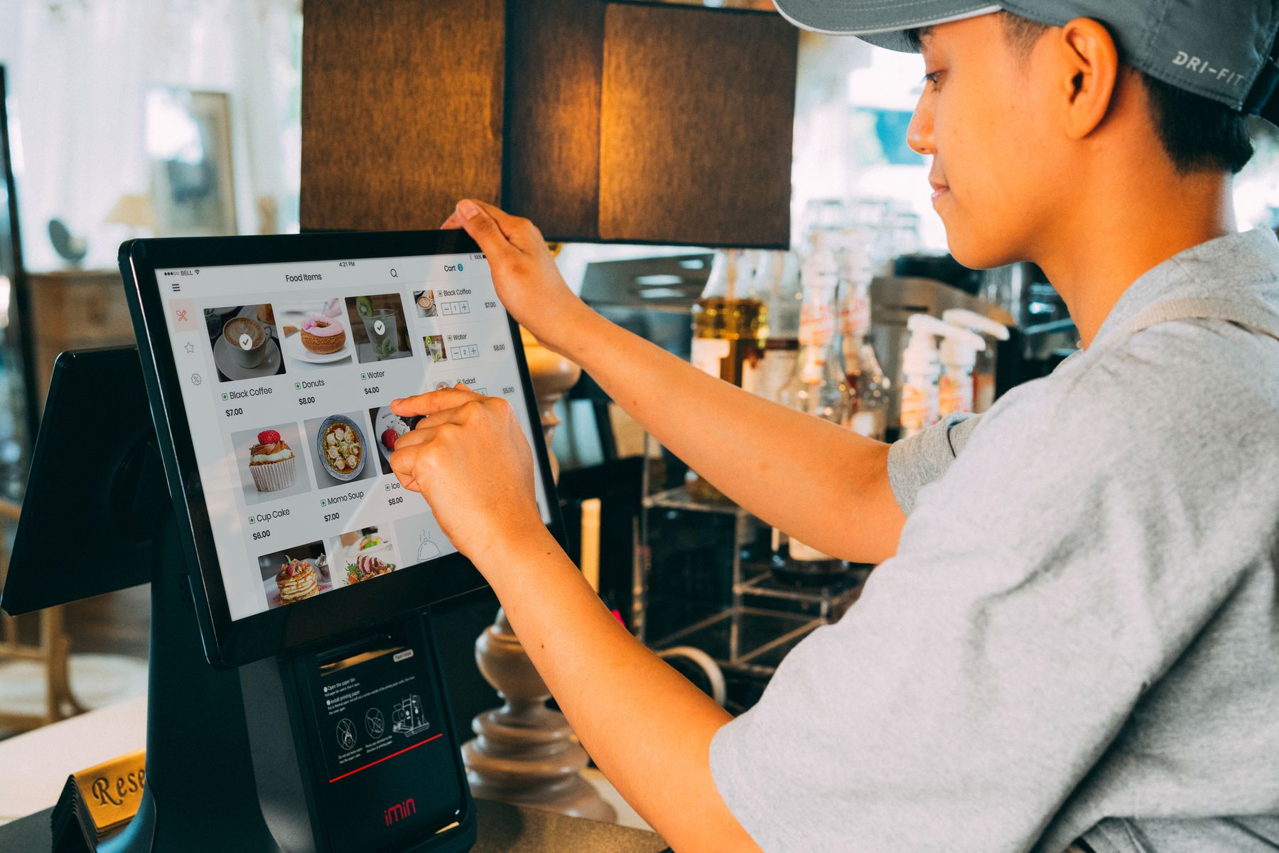A service worker using a touchscreen order terminal. Reference photograph, not company equipment or a menu.